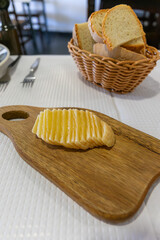 Sliced Alentejo cheese on a wooden cutting board at a traditional restaurant table.