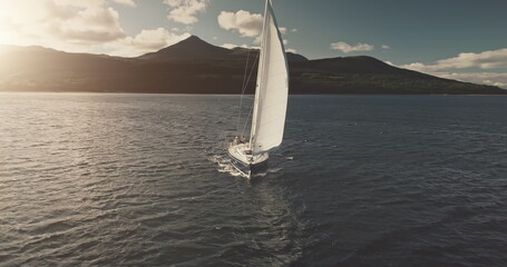 Sun seascape with white sails yacht in open sea aerial. Sailing on sailboats at ocean bay. Luxury...