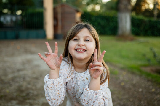 ni&ntilde;a jugando en el jard&iacute;n de casa al atardecer