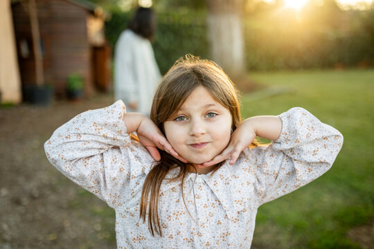 ni&ntilde;a jugando en el jard&iacute;n de casa al atardecer