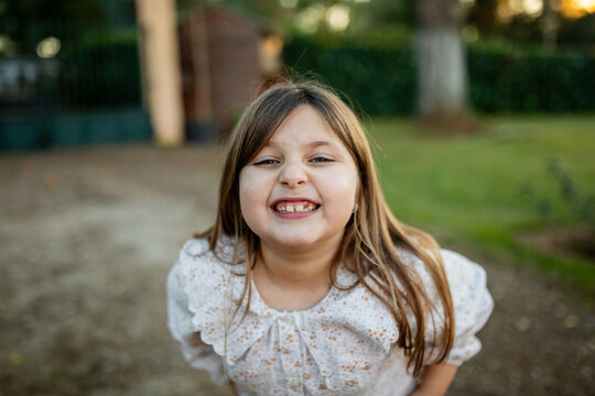ni&ntilde;a jugando en el jard&iacute;n de casa al atardecer