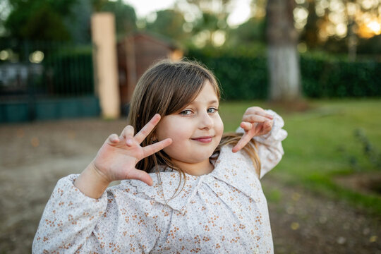ni&ntilde;a jugando en el jard&iacute;n de casa al atardecer
