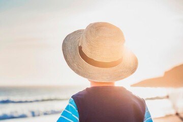 enfant de dos avec un chapeau de soleil, ambiance vacances