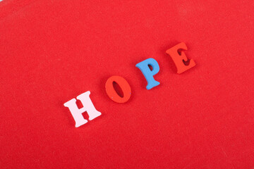 HOPE word on red background composed from colorful abc alphabet block wooden letters, copy space...