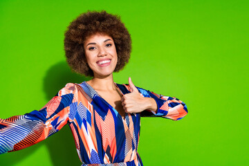 Photo of adorable cheerful woman wear trendy clothes stream video thumb up isolated on vibrant green color background
