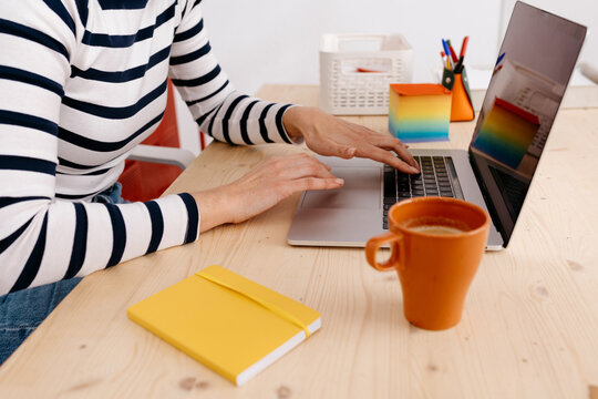 Faceless woman using laptop at workplace