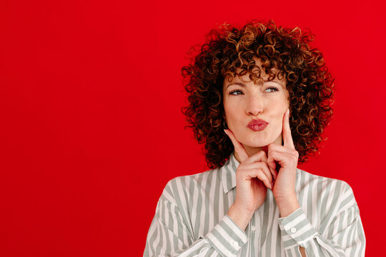 Young female making pouting lips while standing in studio