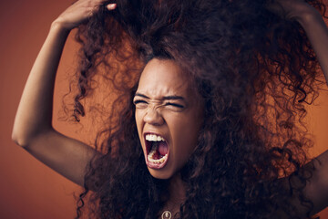 Woman, curly hair and scream with anger in studio on brown background for damage, treatment and bad...