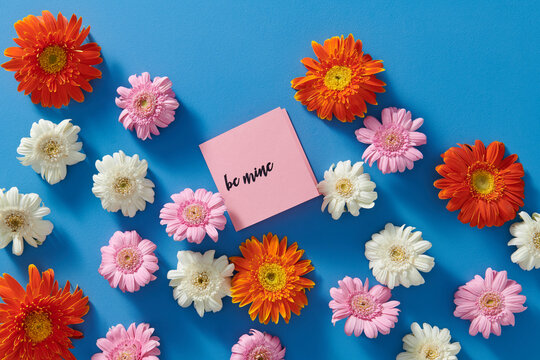 Beautiful background made of bright flower buds with text BE MINE