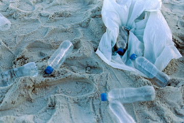 Plastic bottle, rubbish or recycling on sand pollution for clean up, waste management and...