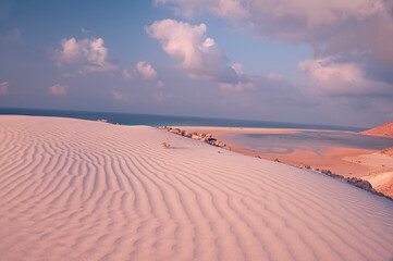 sand dune with a relief pattern of sand and a view of the emerald ocean. Paradise Island,