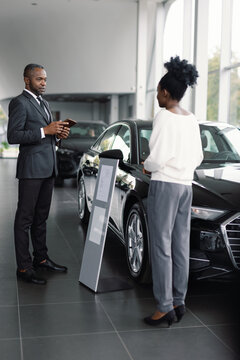 Anonymous customer attentive employee discuss vehicle purchase terms