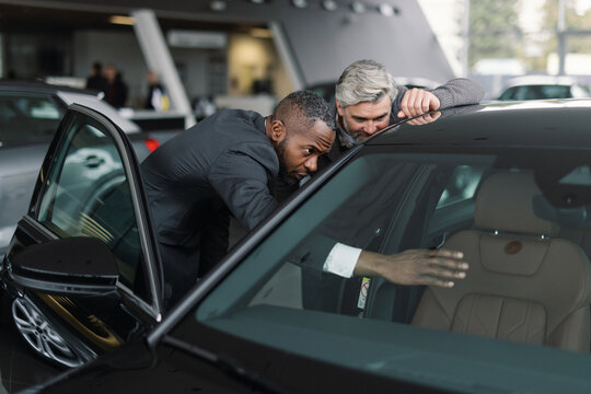 Customer advisor demonstrating car features dealership