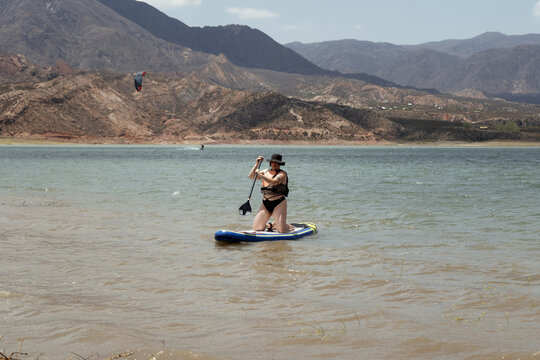 Woman in life jacket at sub board at river at evening
