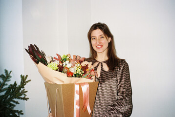 Smiling woman with flowers at home