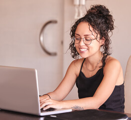 Happy girl, student and typing with laptop for research, browsing or communication on desk at home. Young writer or female person working on technology for assignment, news or online search at house