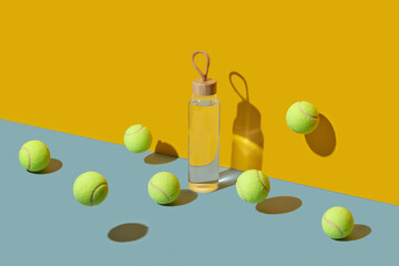 Tennis balls levitating around glass sport bottle of water in studio