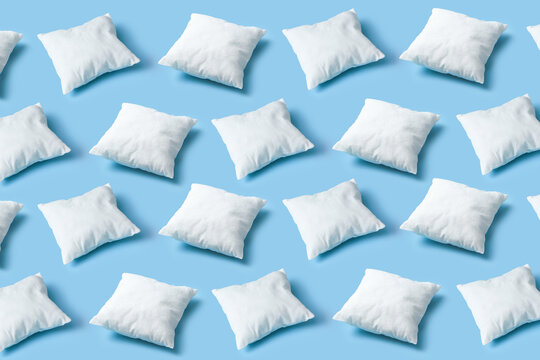 Seamless pattern of white soft pillows repeating on blue background