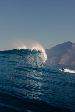 A jet ski speeds towards a giant wave in the Atlantic Ocean