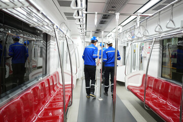 Apprentices engineer checking inside the skytrain at railway engineering facility.