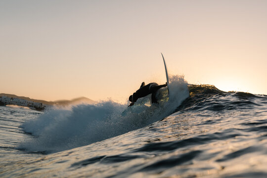 A professional surfer performing a reentry while riding a wave