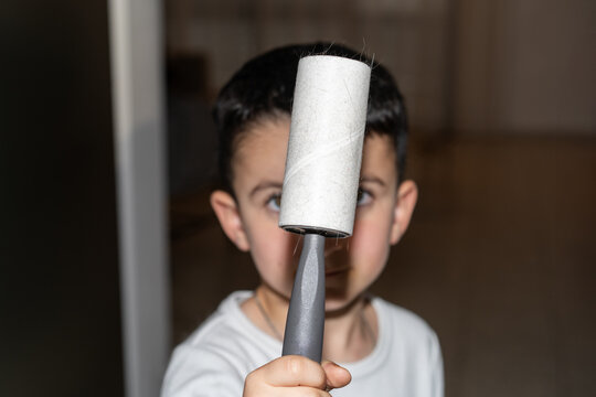 Boy Holds Lint Roller After Clothes Cleaning.Photo With Direct Flash.