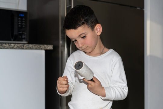 Boy Removes Hair-Covered Sheet from Roller After Clothes Cleaning.