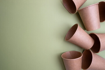 Top view of brown kraft paper cups, straws on a colored background. Recyclable street food packaging. Zero waste. Paper dishes. Disposable takeaway cup