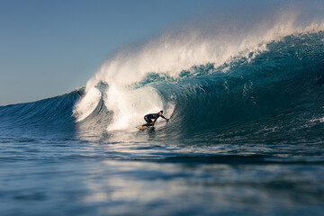 A swimsuit-clad professional athlete skillfully rides a wave