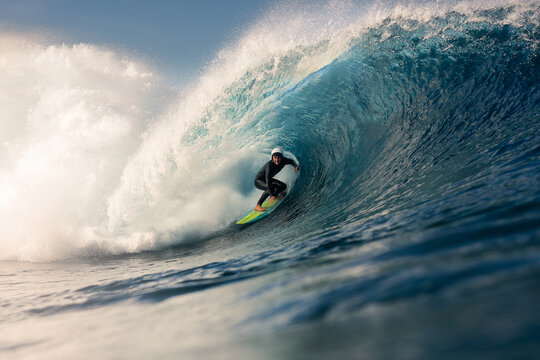 A surfer skillfully rides a giant wave near the Canary Islands