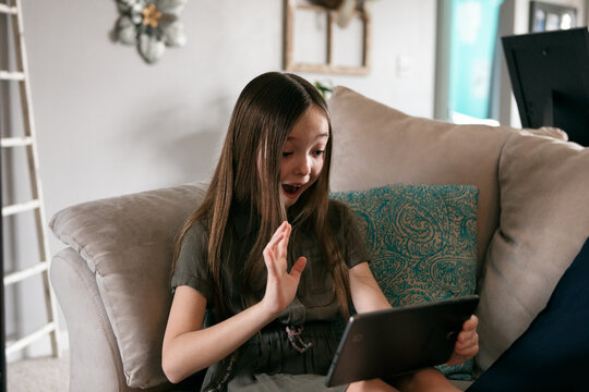 Girl Waves To Friends During Virtual School On Tablet