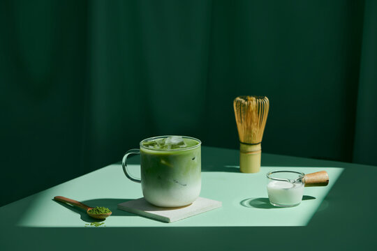Matcha latte and accessories for making on green background