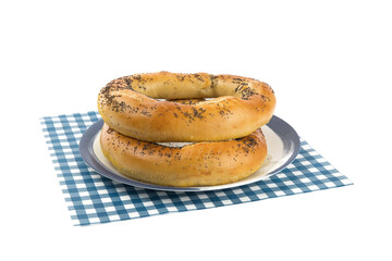 two huge poppy seed pretzels on a blue plate isolated on white