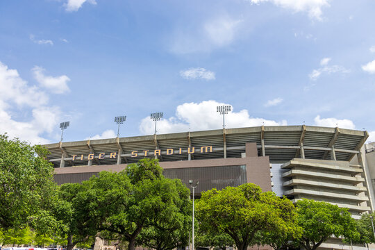Tiger Stadium surrounded by lush green trees, blue sky and clouds on the Campus of Louisiana State University in Baton Rouge Louisiana USA