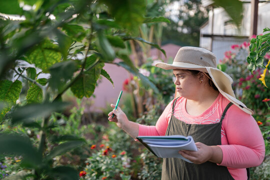 Woman counting plants with a notebook and a pen.