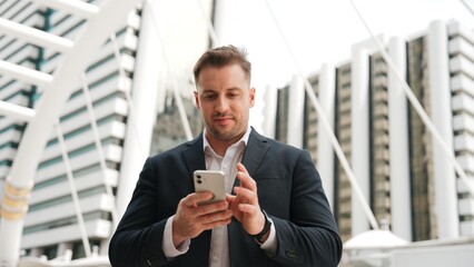 Caucasian business man checking mobile phone and looking report sales from marketing team while...