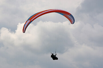 Paraglider flying in a cloudy sky	