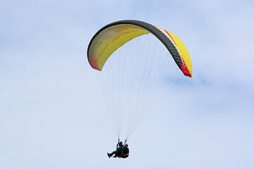 Tandem Paraglider flying in a blue sky	