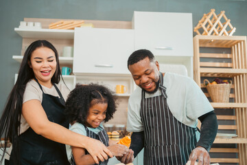 Fototapeta premium In a home kitchen, black father and his daughter bond over cooking a meal food, their laughter and love filling the air, embodying the joy of African American family life, Father's Day concept