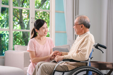 Celebrating Father's Day, Senior Asian grandfather in a wheelchair shares a happy moment at home,...