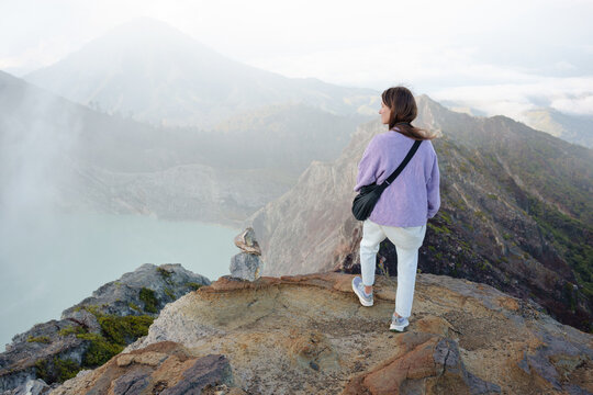 Female Travel Looking Over Mountains and Misty Landscape at Dawn