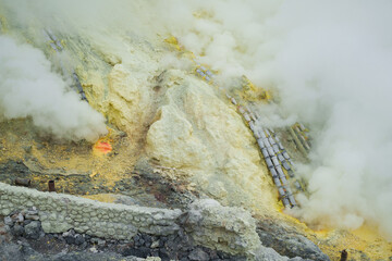 Sulfur open mine in an active volcano crater, toxic gas and ore