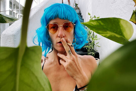 Young woman with blue wig smoking a joint 