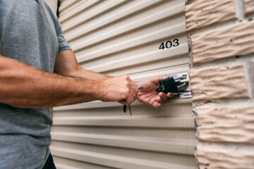 Storage: Man Unlocking Padlock On Unit