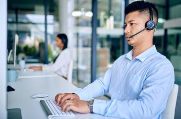 Call center, man and headset with computer, serious and typing for telemarketing, sales and customer service. Company, agent and corporate with internet, consulting and technology for communication