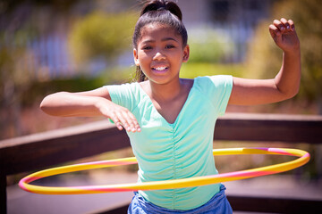 Happy girl, portrait and playing with plastic hoop at park for fun game, activity or outdoor...