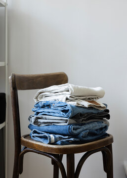 stack of folded pants on a chair 