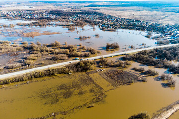 Aerial view of the area flooded during the spring flood through which the road passes. Flood of the Protva River in Kaluga region, Russia