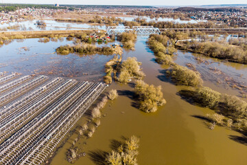 A river spill in a rural area from the air, large areas of land flooded with water during the...