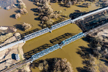 An aerial view of railway bridges crossing a river that overflowed during a flood